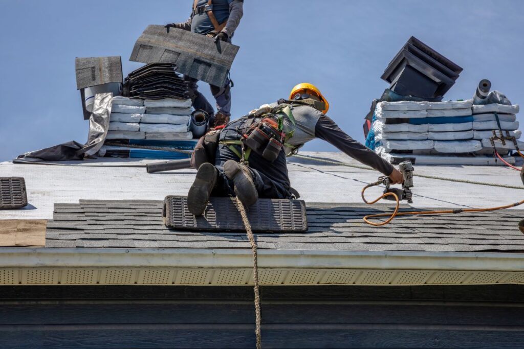roofing companies in knightdale nc worker using nail gun repairing shingles roof